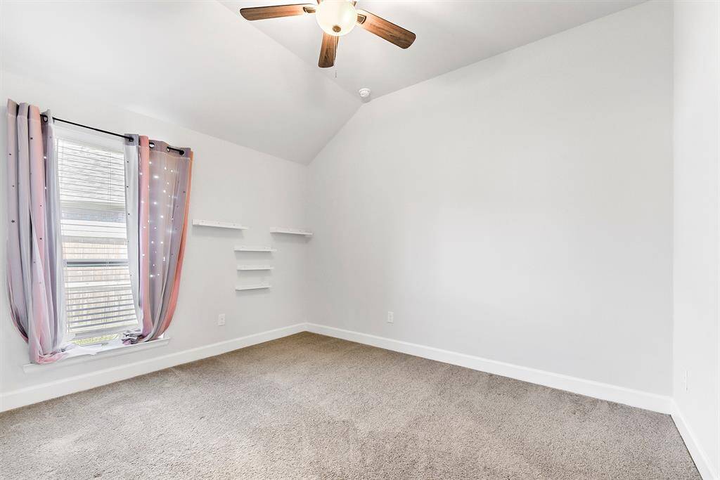 The junior ensuite features an attached full bathroom, high ceilings with a ceiling fan, a walk-in closet, and plush carpeting for added comfort.