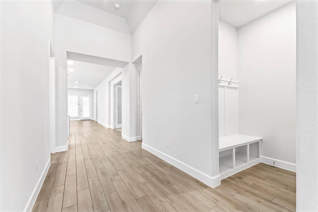 From the front entryway, you’ll find the mudroom, which leads to the spacious 2-car garage. It’s the perfect spot to drop off items and get ready for school or work, featuring built-in storage, hooks, and a convenient bench seating area.