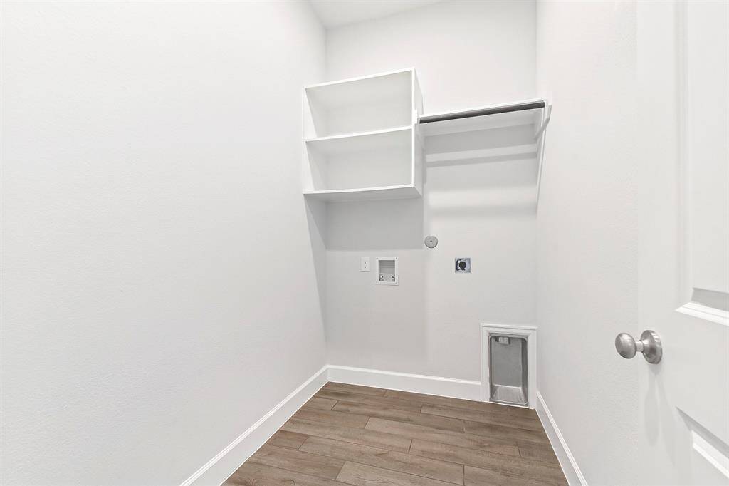 The spacious utility room offers built-in shelving and a hanging rod, with plenty of room for an additional refrigerator or freezer.