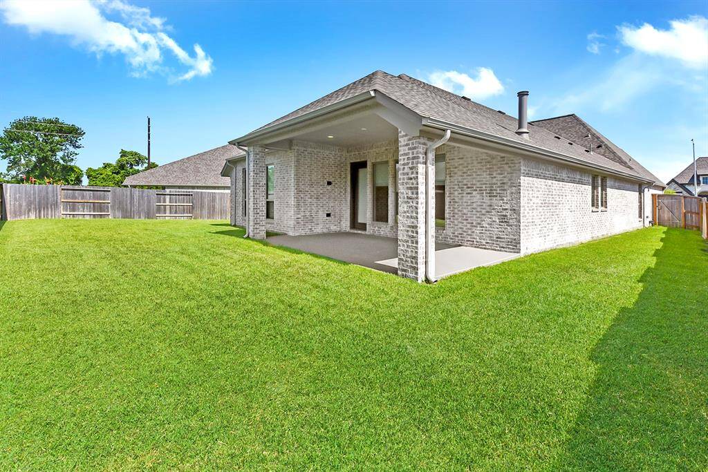 The spacious backyard features an extended patio, offering plenty of room for BBQs, relaxing, or outdoor dining.