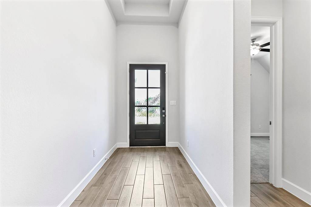 As you enter the home, you’re greeted by a spacious formal foyer with a tray ceiling and plenty of room for decorative furnishings or bench seating—setting a warm and welcoming tone.