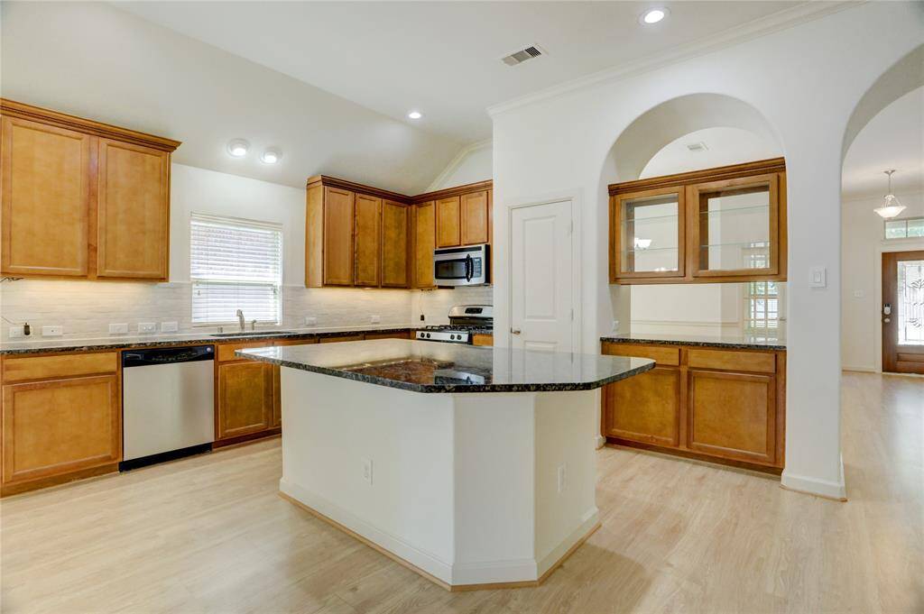 Incredible kitchen offers wood cabinetry, designer backsplash, granite counters, and stainless steel appliances.