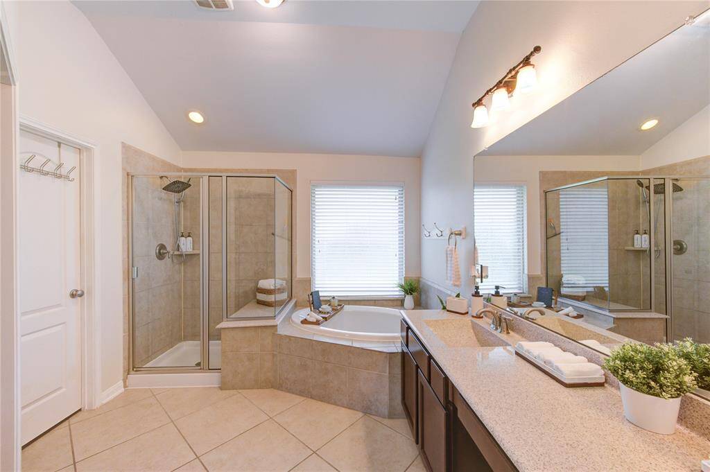 The primary bathroom offers a spa-like experience with a luxurious soaking tub and a spacious walk-in shower. Thoughtfully designed for both relaxation and functionality, this serene space combines comfort with elegant finishes for a truly tranquil retreat. It also features a huge walk in closet.