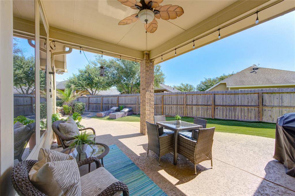 A covered patio with ceiling fan provides the perfect outdoor entertaining space, ideal for al FRESCO dinning, grilling, or relaxing in the shade while taking in views of the gorgeous POOL and manicured yard.