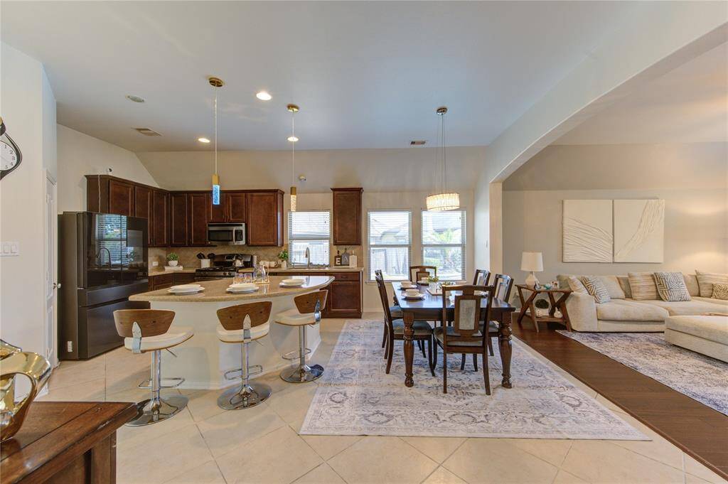 This open-concept kitchen, dining, and living area offers a seamless flow that's perfect for both everyday living and entertaining. With spacious sightlines, abundant natural light, and a cohesive design, the space feels airy, connected, and welcoming.