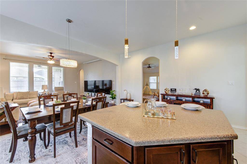 At the heart of the kitchen is a stunning, oversized granite island that offers both beauty and functionality. Perfect for meal prep, casual dining, or entertaining guests, it serves as a central gathering spot with ample seating and storage