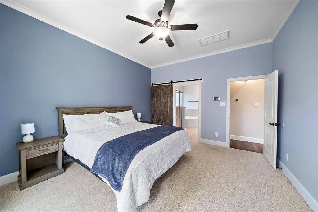 Modern barn door leads to an elegant ensuite.