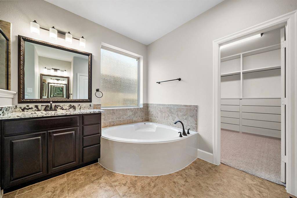 A dreamy corner soaking tub offers the perfect place to unwind after a long day.