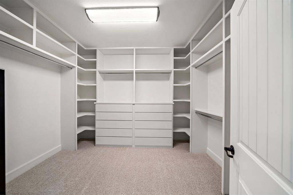 Oversized walk-in closet with custom solid wood built-ins and 10-drawer soft-close dresser.