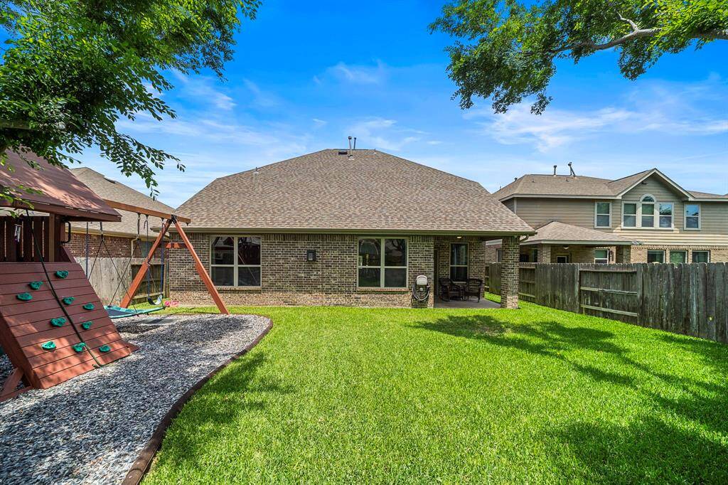 Spacious covered patio is made for entertaining — complete with recessed lighting and a ceiling fan.