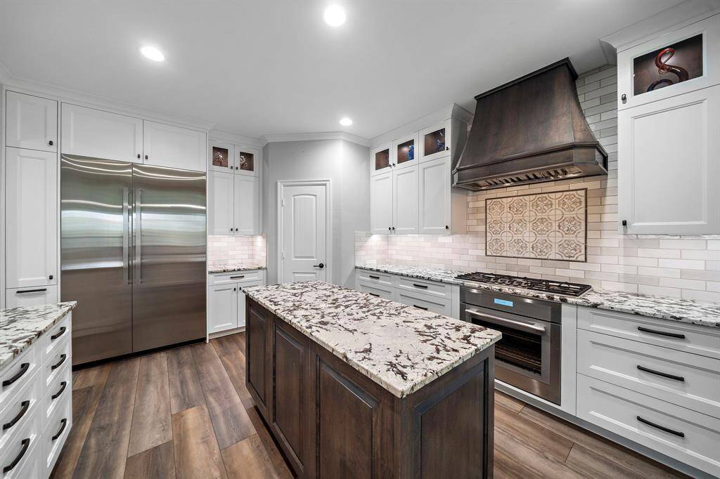 Flush-mount top of the line Thermador appliances + oversized 48" JennAir fridge (yes, it stays!) Statement custom vent hood crafted by hand, paired with commercial-grade ventilation to keep your kitchen cool.