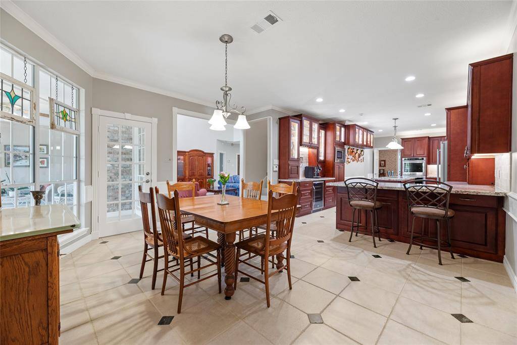 The breakfast area sits next to the kitchen and offers direct access to the sunroom through a rear door. A large window provides a lovely view of the outdoor space, filling the room with natural light.