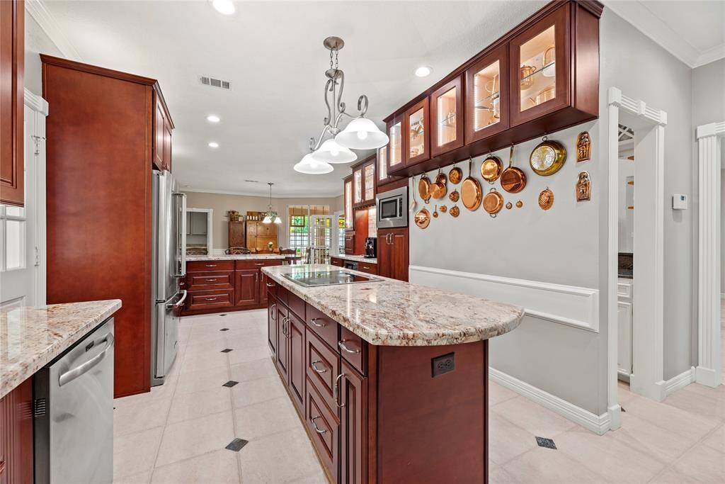 Alternate view of the kitchen featuring the large island, creating an inviting and functional space for cooking and entertaining.
