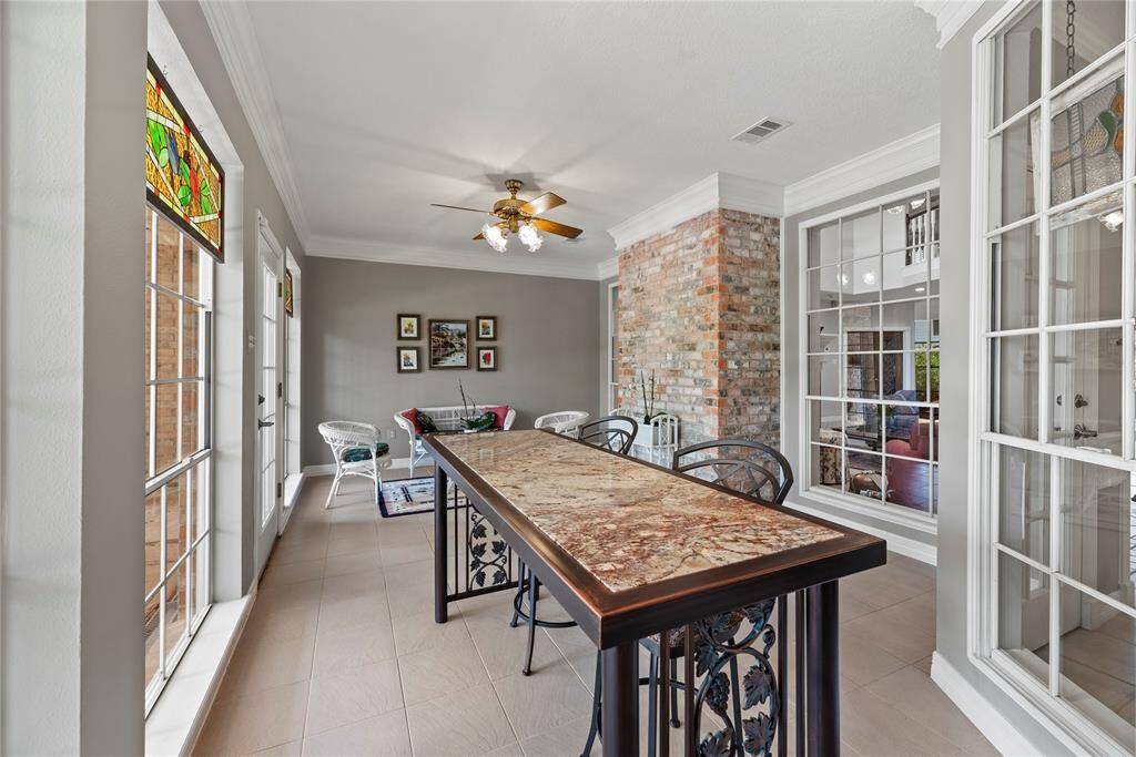 The sunroom features large windows with excellent views of the covered patio and mature rear yard landscaping.