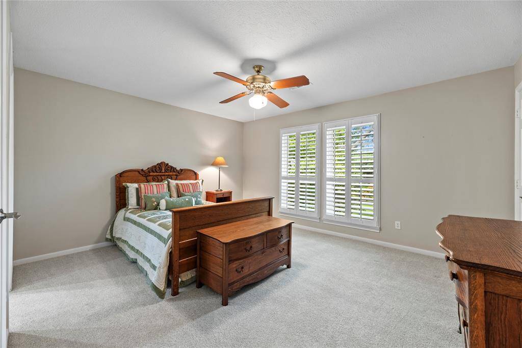 This secondary bedroom (2) on the second floor features carpeted flooring, a ceiling fan, and large windows.  The room measures 15.1x12.7