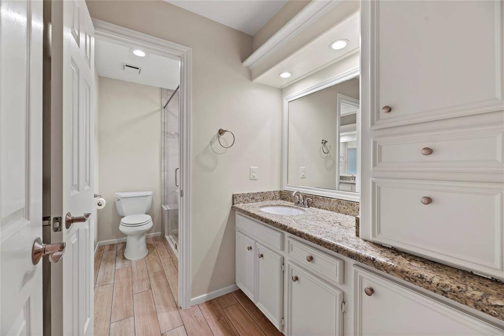 Jack and Jill bathroom features ample storage, a spacious vanity with sink, and a large mirror—perfect for shared use while maintaining privacy and functionality.