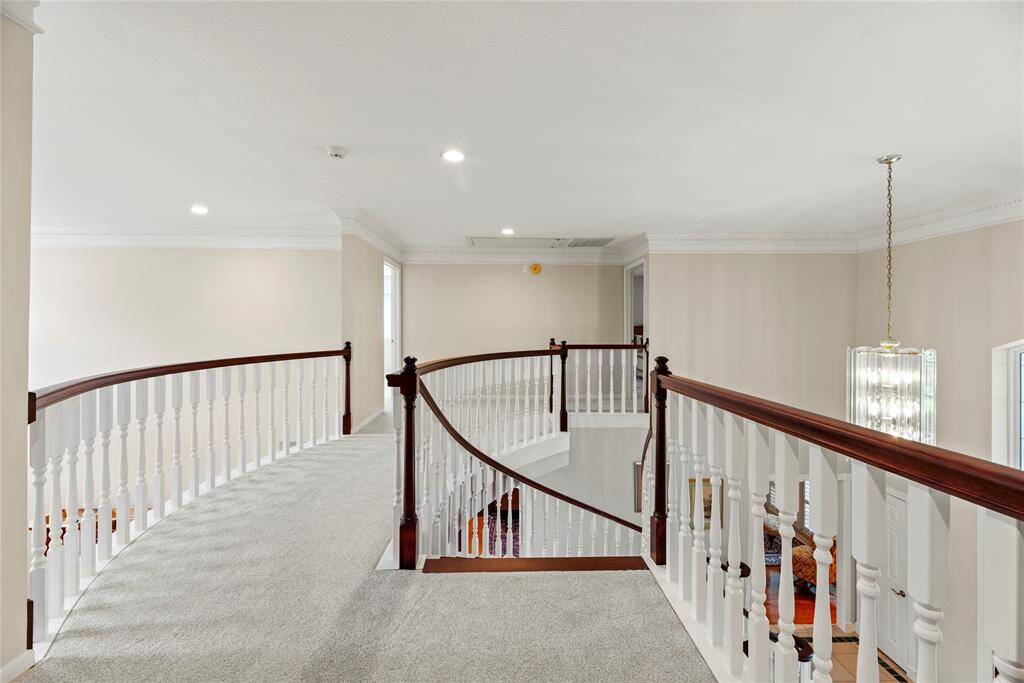 The upper landing showcases a beautiful curved staircase with 3/4" recently added and stained oak treads, updated carpet flooring at the landing areas and walkways. The open layout enhances the sense of space, creating an airy and elegant transition between the two sides of the second floor.
