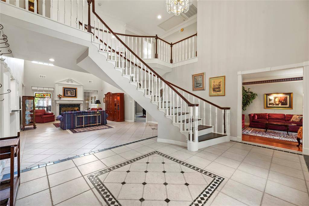 Alternate view of the foyer featuring the open layout that leads to a spacious family room with a fireplace and abundant natural light, perfect for entertaining.