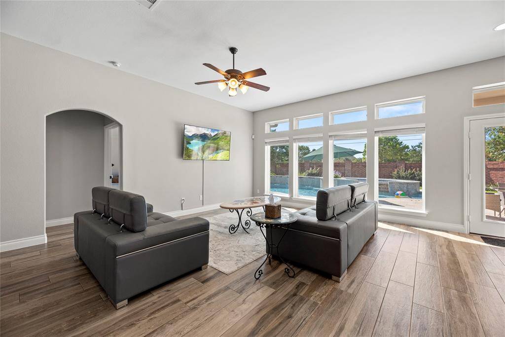 A closer look at the living room. The great windows look out on your pool, and the door on the right takes you outside. Let's go outside!