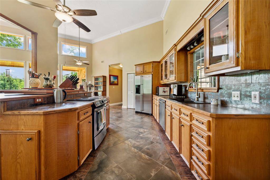 Galley style kitchen. Upper glass cabinets to show case your favorite dishes. Refrigerator is included. Walk in pantry to the left of the refrigerator.
