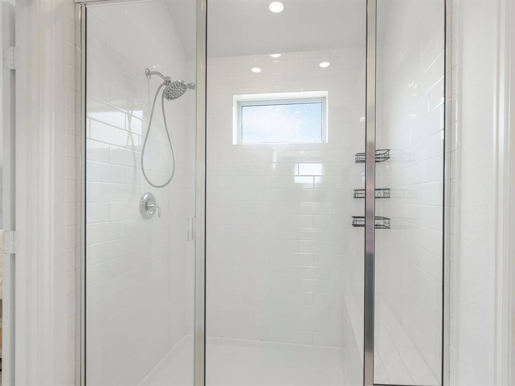 This walk-in shower features classic white subway tile, a clean and simple design and a window that brings in natural light.