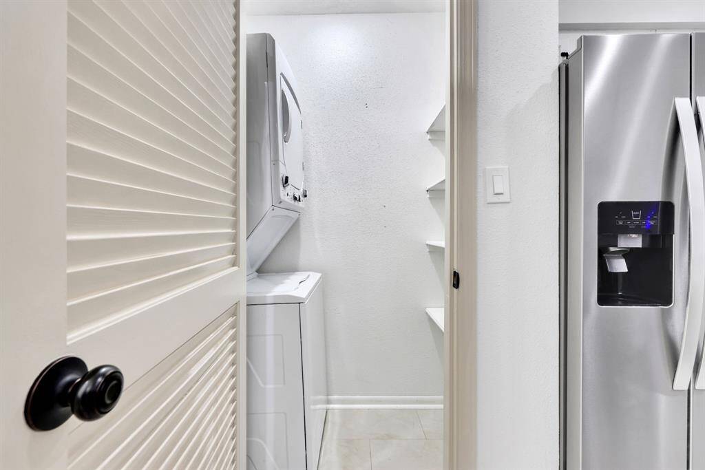 Laundry room equipped with a new stackable washer and dryer for convenience.