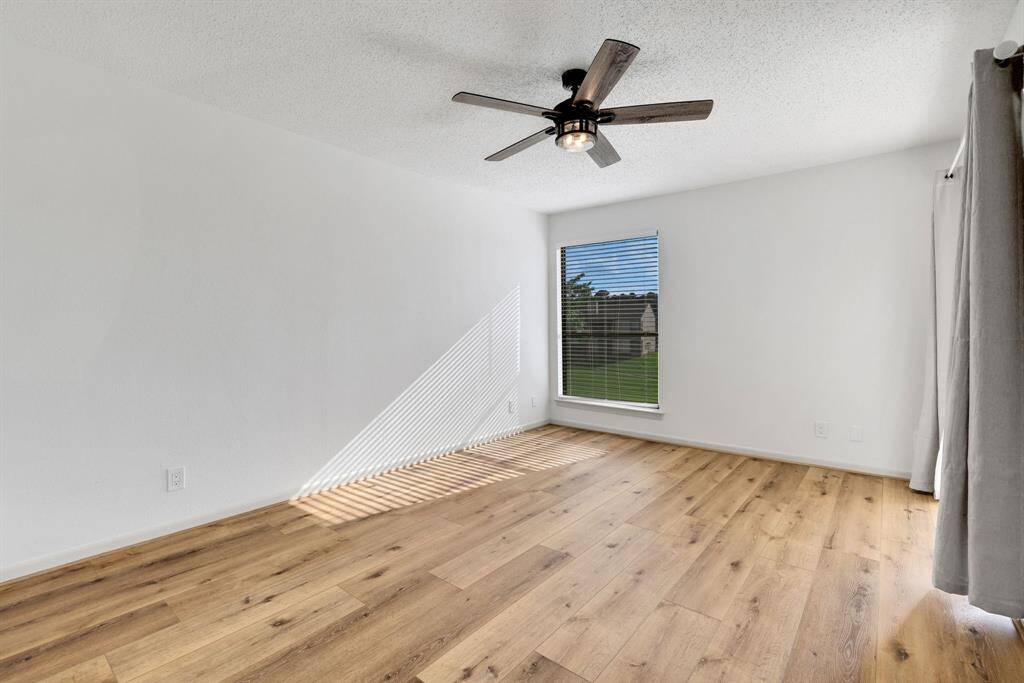 Spacious primary bedroom featuring direct access to the screened patio overlooking the lake.