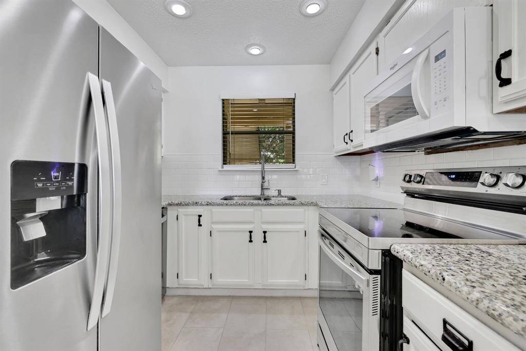 Freshly updated kitchen with subway tile backsplash and new appliances.