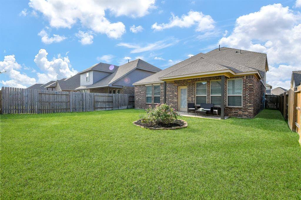 LARGE PRIVATE BACKYARD WITH BEAUTIFUL FLOWER BED AND GREEN GRASS