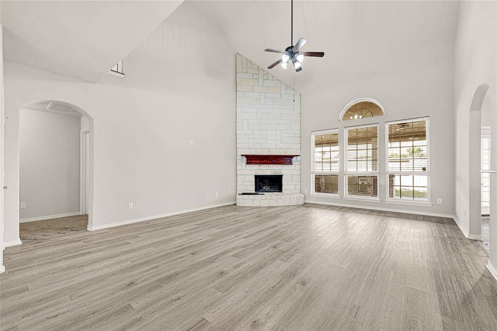 Living room w/ new floor, high ceiling and fireplace
