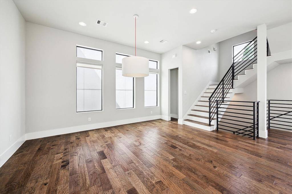Enjoy cozying up for movie nights in this spacious living area with convenient access to a half bath through the far right archway. Find custom-made blinds throughout the home, adding additional privacy.
