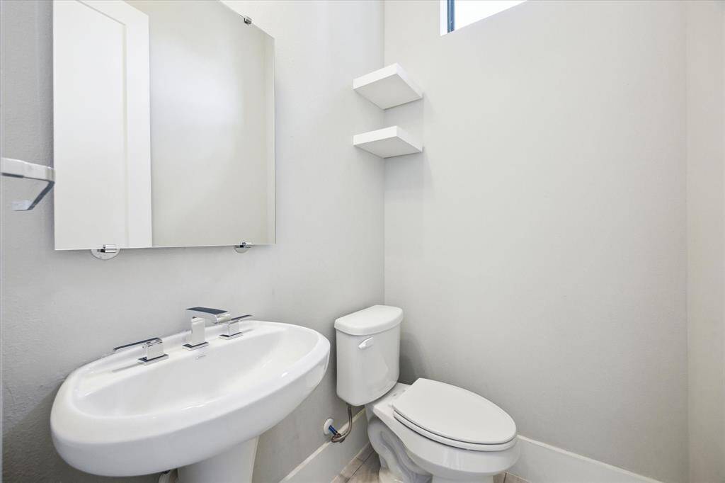 Conveniently located half bath on the second floor off the living area. There is an additional space/nook for storage between the archway and door into bathroom, a great area to store living room blankets or to add a slim shelving unit.