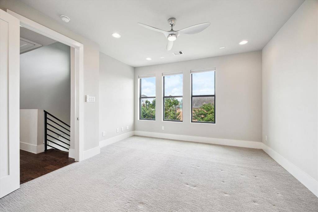 On the third floor you will find a large primary bedroom, featuring a modern ensuite, spacious walk-in closet, and a modern ceiling fan/light combo. This room comfortable fits a king size bed, night stands, and a dresser.