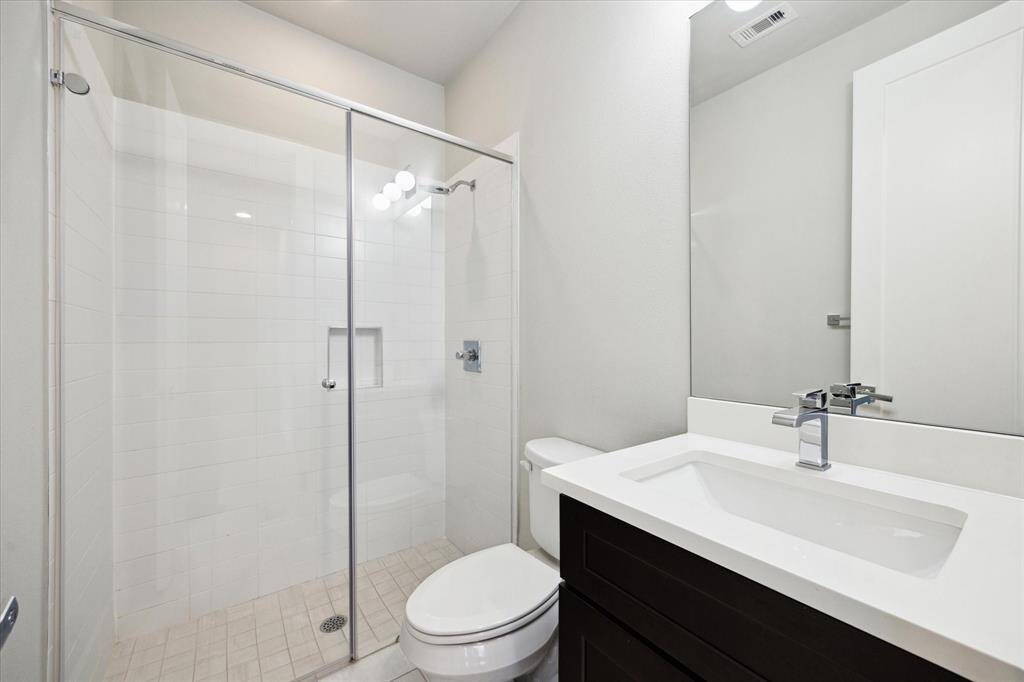 Another beautiful and stylish full bath, found in the first floor secondary bedroom. You will love this large walk in shower with glass doors and modern finishes.