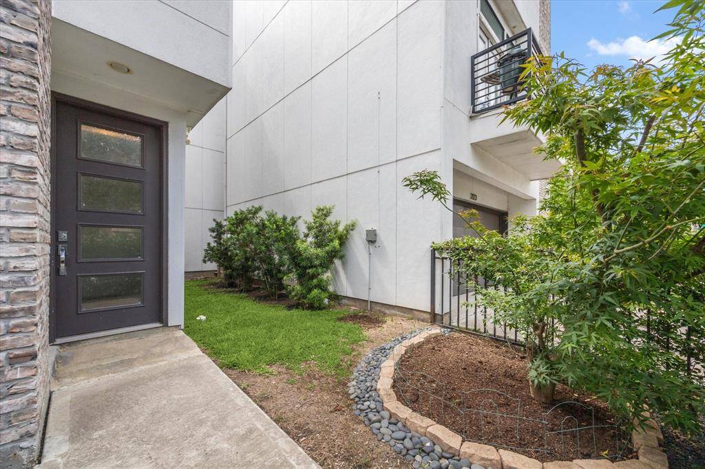 The spacious front and side yard is fully fenced and beautifully landscaped with multiple trees. More lush greenery not pictured to the right of this photo creates privacy making it the perfect space for the family pet or entertaining guests.
