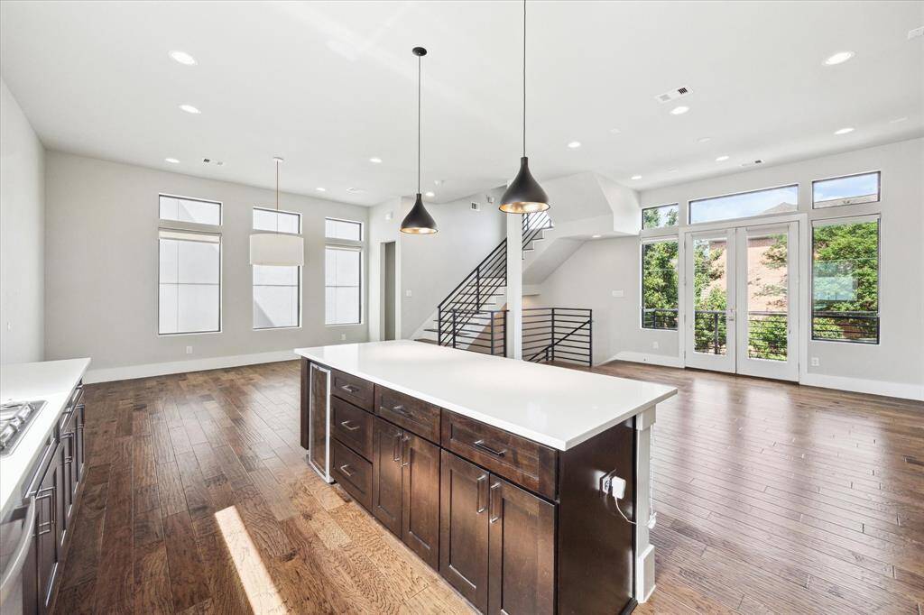 Plenty of storage and soft close drawers/doors in every cabinet. A wine fridge can be seen to the far left of island and a gas cooktop with a retractable downdraft range hood, to the left of this photo.