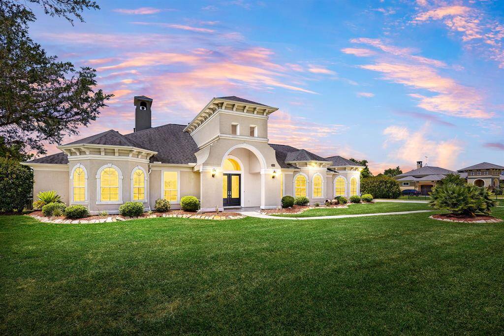 Elegant single-story estate on over an acre, featuring a gated driveway, a resort-style backyard, and a dream garage for car enthusiasts.