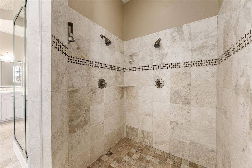 Dual shower heads in the large walk-in primary shower provide a spa-like experience.