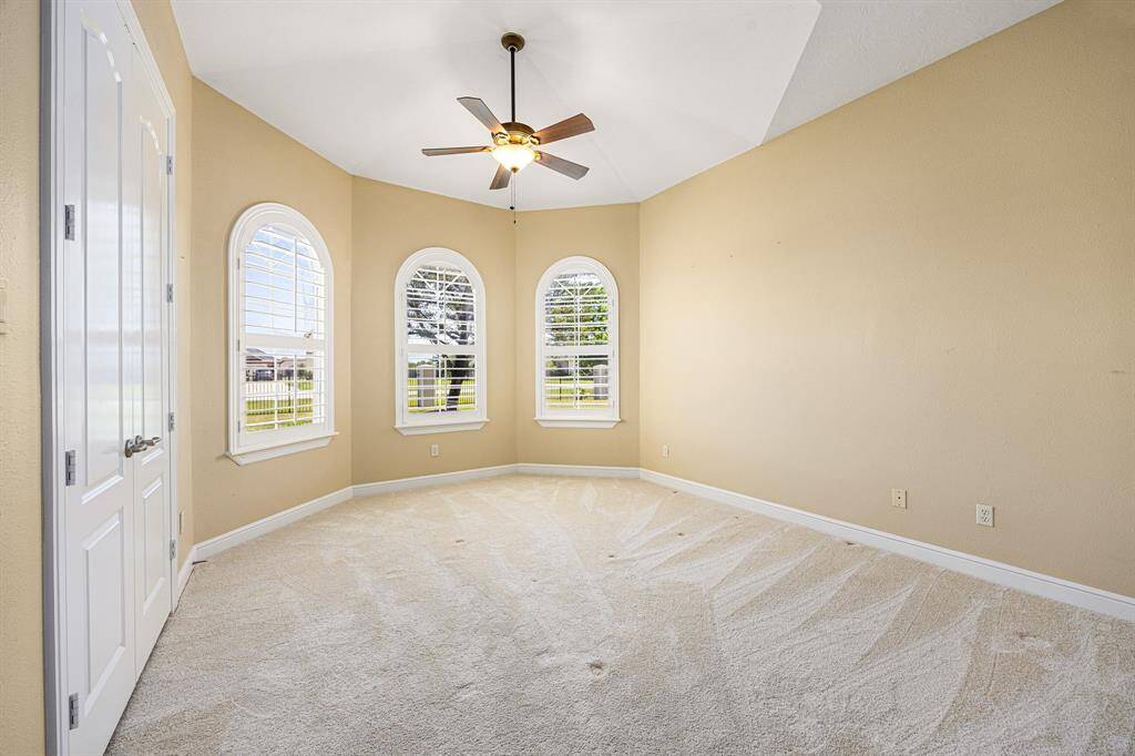 The secondary bedrooms are highlighted by curved wall details, soaring ceilings, custom shutters, and a neutral color palette that enhances their openness and charm.