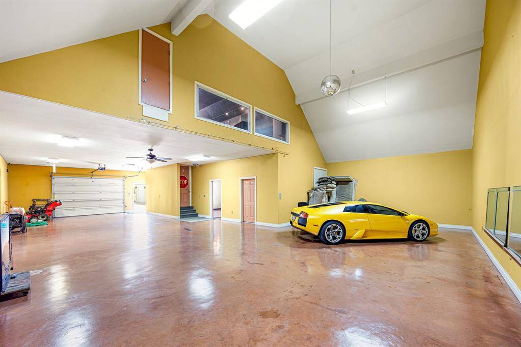 Upstairs, the red door leads to extra attic and storage space, though it’s not accessible from the main upstairs area. The car in the photo is shown for scale. The garage apartment/office offers a private entrance and bathroom, ideal for guests or work-from-home needs.
