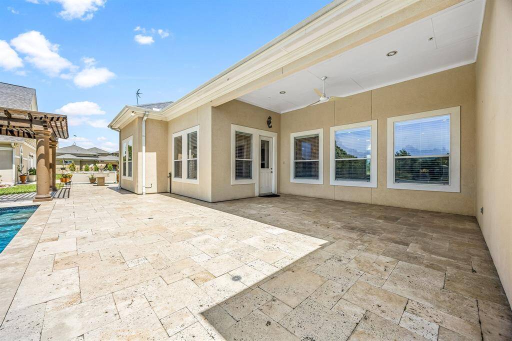 Covered back patio has expansive travertine decking.