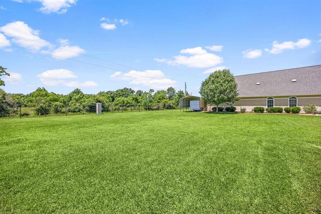 The lush green yard provides a private retreat with no neighbors behind, and you'll have easy access to the RV-covered space just behind the garage.