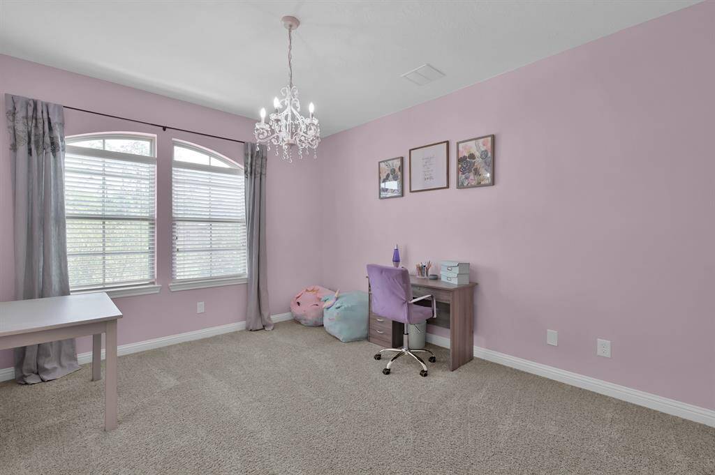 This room features soft pink walls, cozy carpet, and ample natural light from large windows.  This third bedroom shares a Jack and Jill bathroom layout.