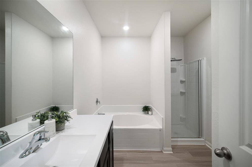 This spa-like bathroom contains a garden tub and a walk-in shower with an upgraded rain showerhead.