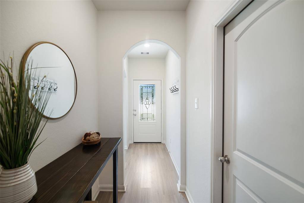 The light and bright foyer is beautifully accented by the home's lead glass front door and gleaming LVP floors.
