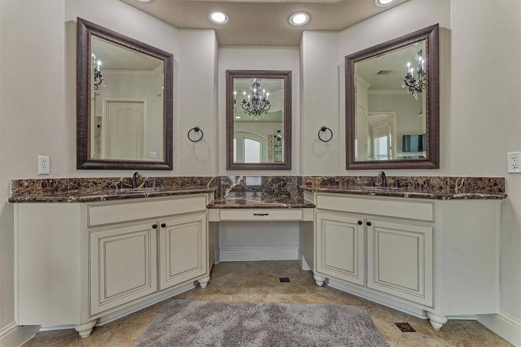 Primary bathroom featuring jetted tub, his and hers sinks and large separate shower.