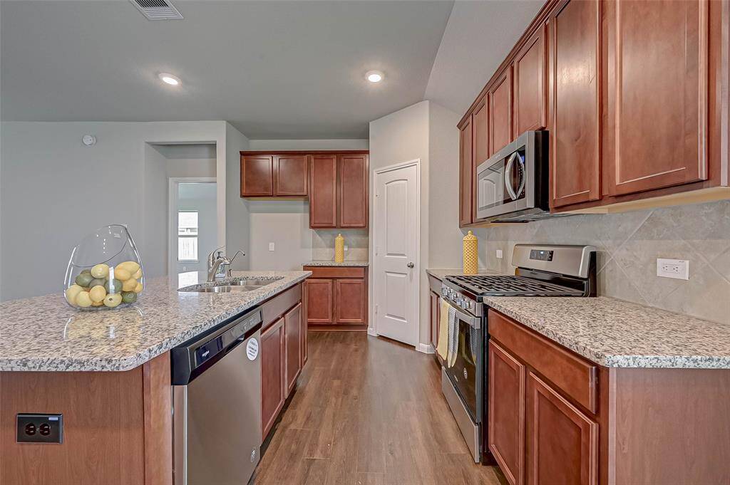 The kitchen island is oversized, perfect for prepping meals and casual dining