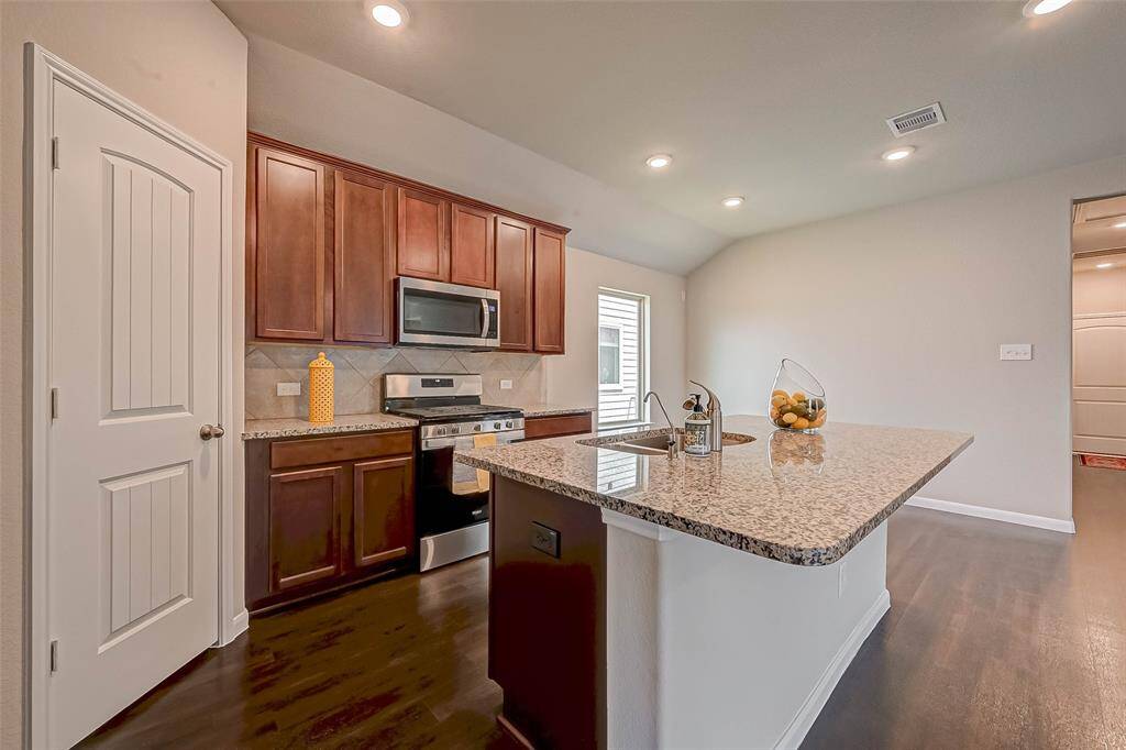 The kitchen island is oversized, perfect for prepping meals and casual dining