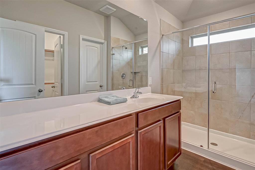 Includes a stylish vanity with clean lines and a glass-enclosed walk-in shower