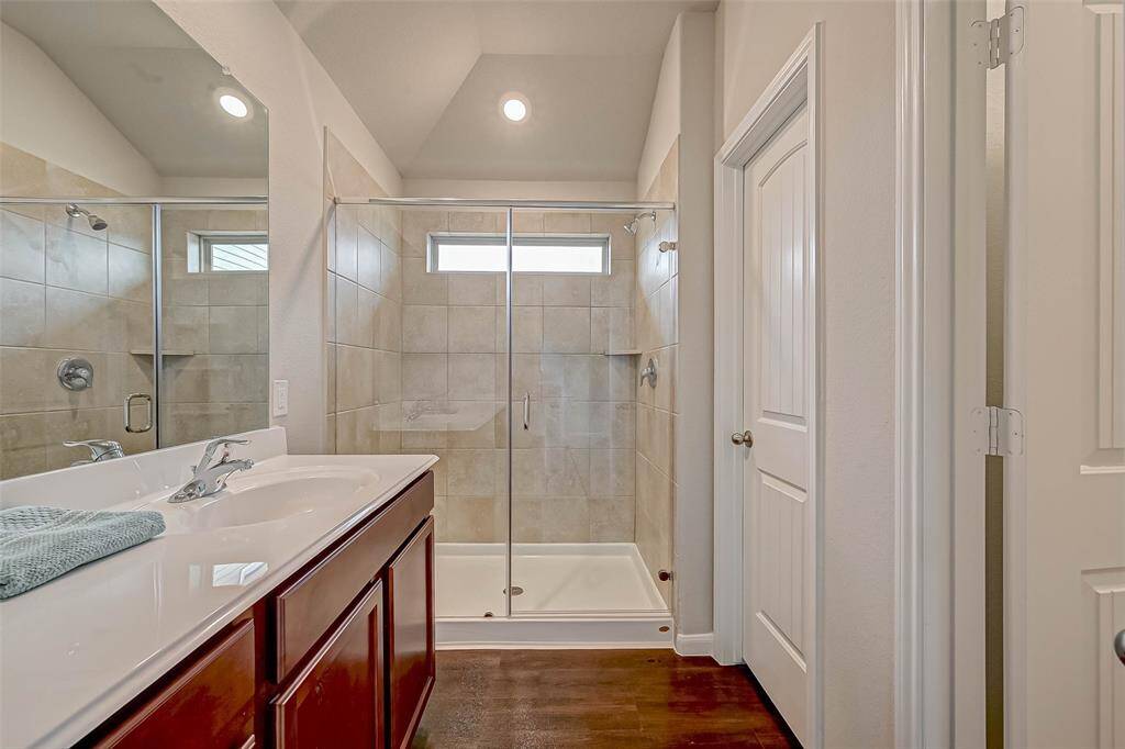 Includes a stylish vanity with clean lines and a glass-enclosed walk-in shower